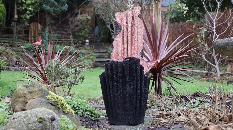 Concrete planter made of bath towel in a yard