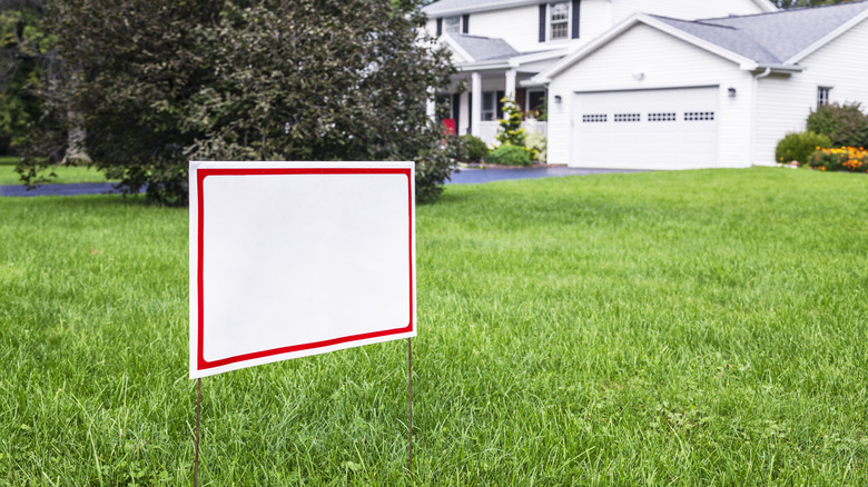 A blank yard sign in front of a house
