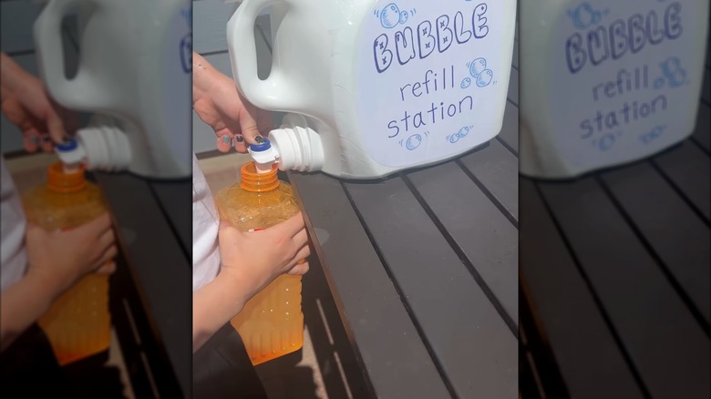 someone pouring bubbles into plastic container from laundry detergent bubble station