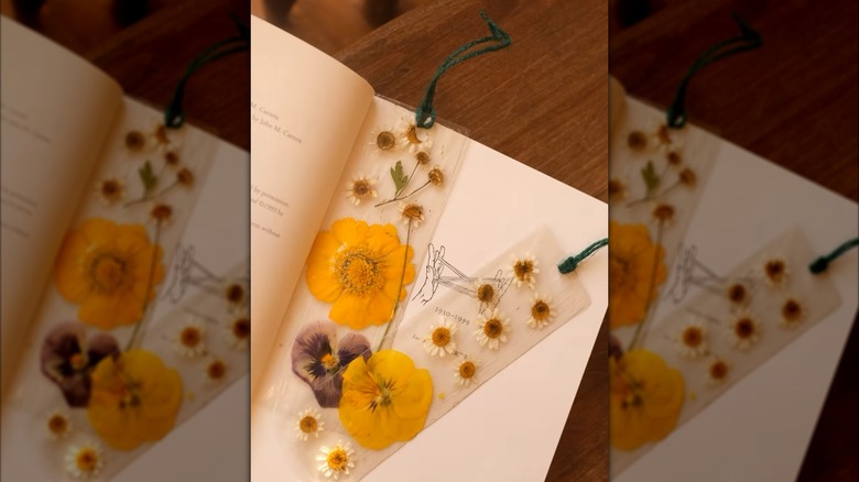 two plastic bookmarks with flowers in book