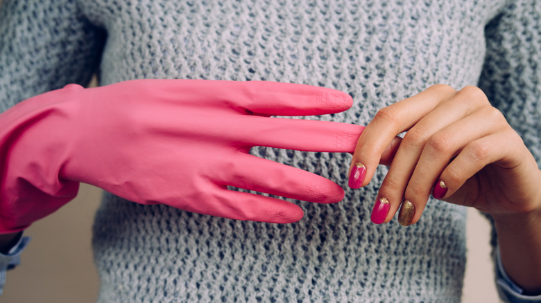Woman removing pink glove from her hand