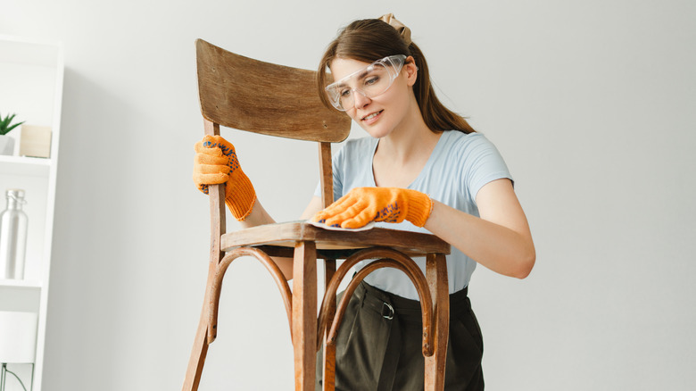 craftswoman staining a wooden chair