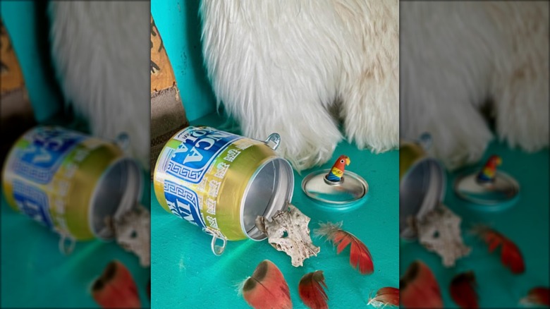 Tipped soda can with small objects spilling out