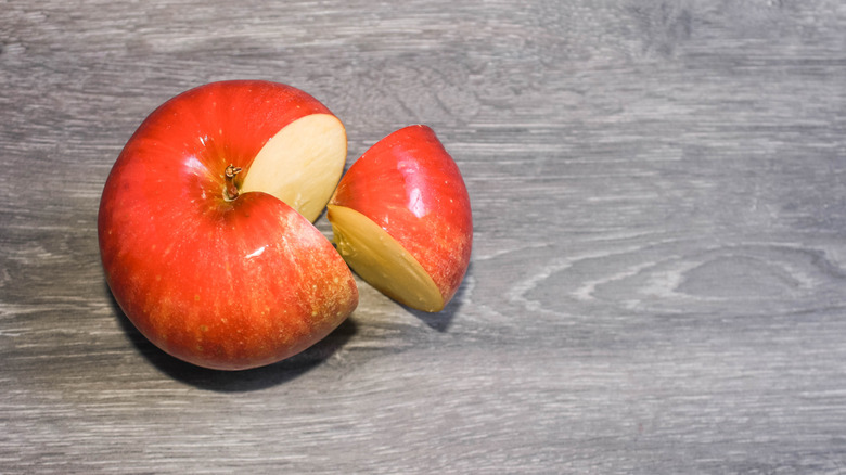 An apple with a quarter cut out