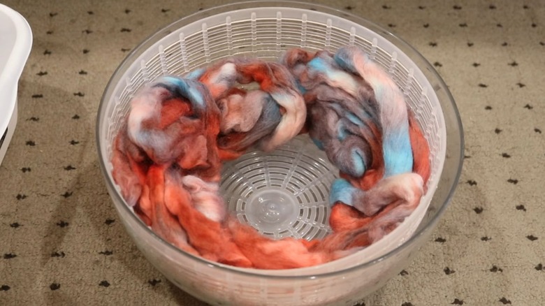 Hand-dyed roving sits in a salad spinner.