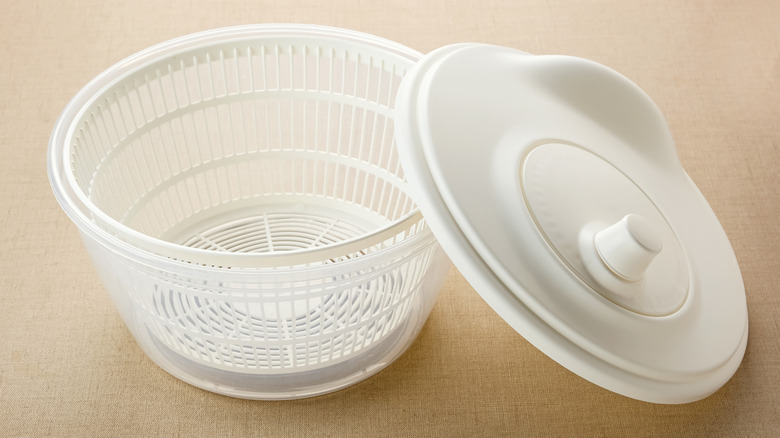 Empty white salad spinner with lid off