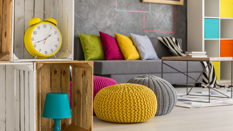 Colorful knitted poufs in yellow, pink, and gray