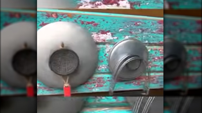 A rack with pan lids and a board.