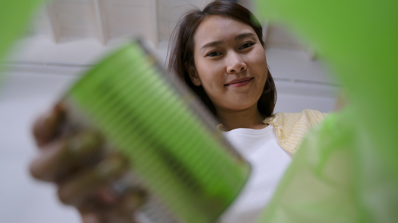 woman saving can from trash