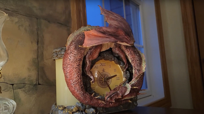 A dragon is sculpted around the amended face of an old alarm clock.