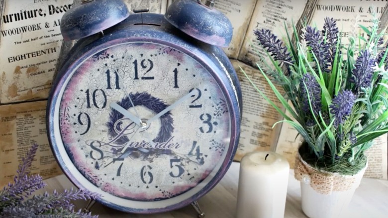 An old alarm clock is made new again using decoupage and paint in a lavender theme.