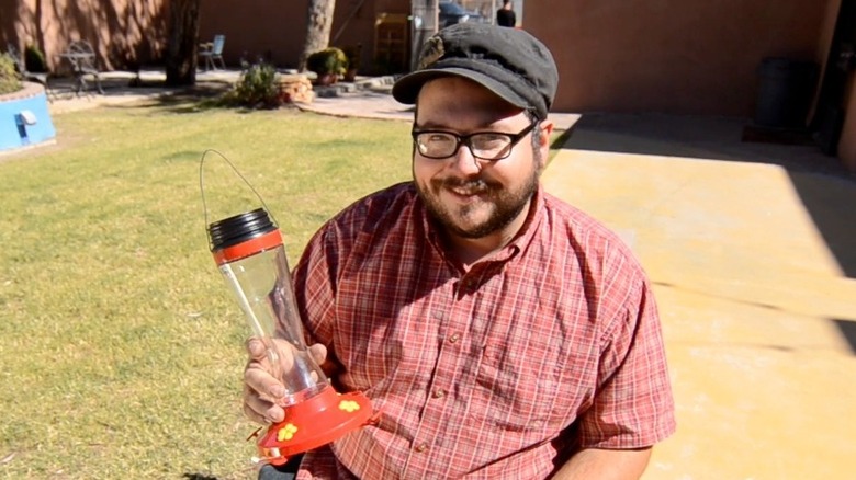 Man sitting with solar hummingbird feeder