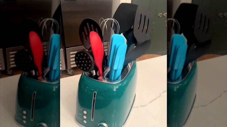 Green toaster with kitchen utensils in slots