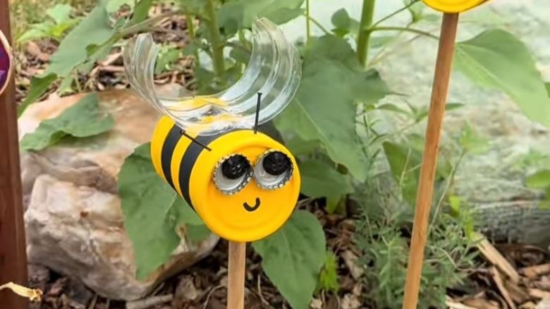 A decorative bumblebee yard pick in a garden.