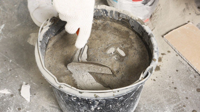 Hand mixing cement in a bucket