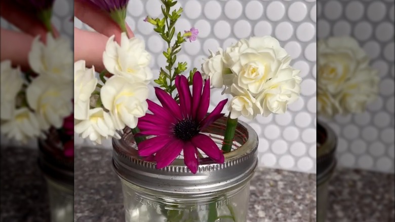 Someone using netting on to arrange flowers.