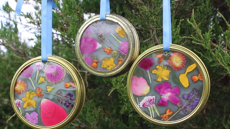 Mason jar lid flower suncatchers attached to a blue ribbon.
