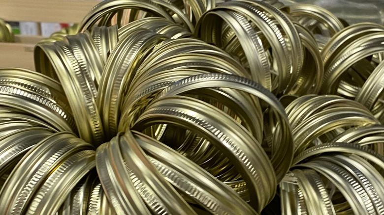 A pile of gold mason jar screw band lids.