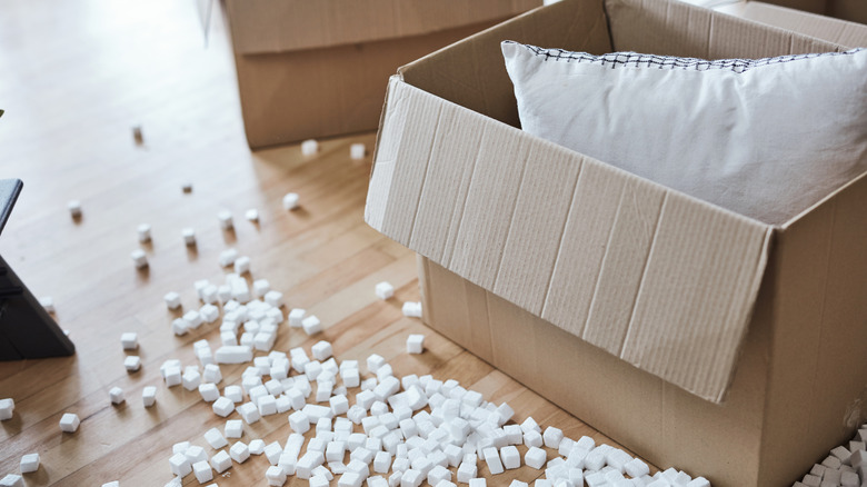 a pillow in a cardboard box surrounded by packing peanuts