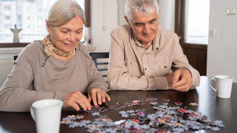 Senior couple puts together puzzle
