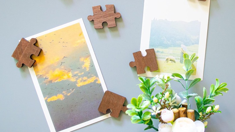 Wooden puzzle pieces made into magnet holding pictures on fridge