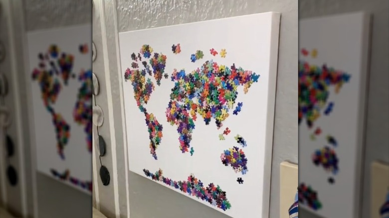 Canvas covered with puzzle pieces shaped into map of the world