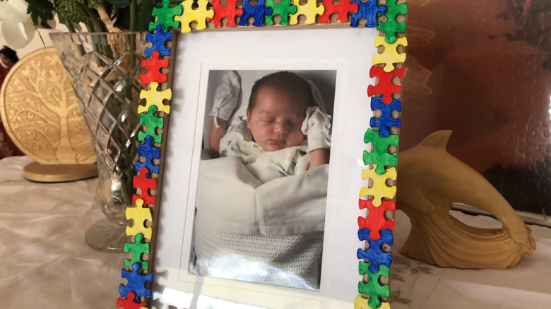 Picture frame decorated with puzzle pieces framing a picture of a child.