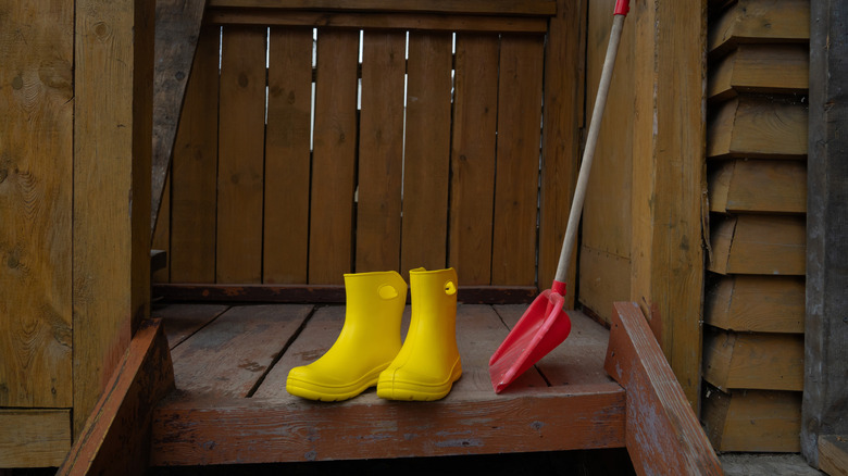A pair of yellow rain boots on a wooden porch