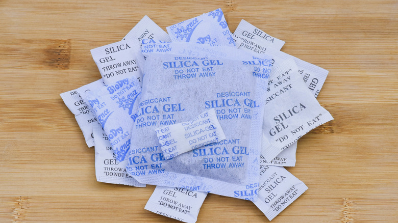 Silica gel packets on a wooden background