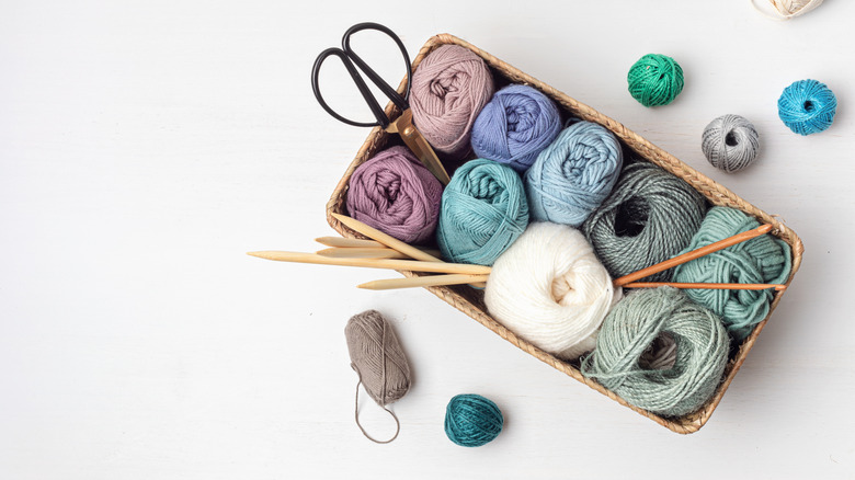 A woven basket filled with knitting supplies