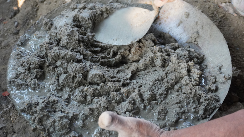 A man mixing a bucket of concrete by hand