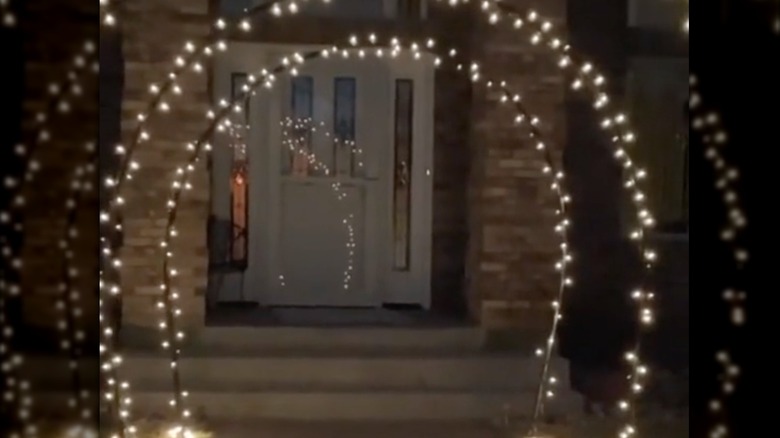 Arched outdoor lights lit near front door.