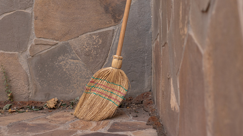 An old broom leaning on a corner
