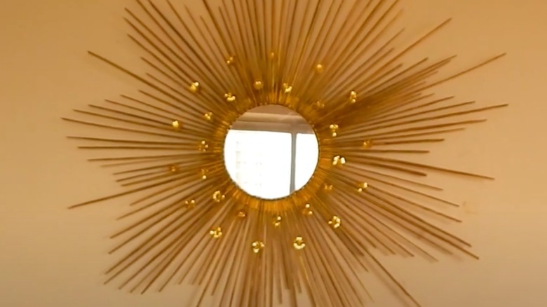 Golden spiky mirror hanging on wall