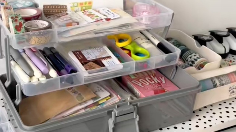 An open tackle box with different craft supplies.