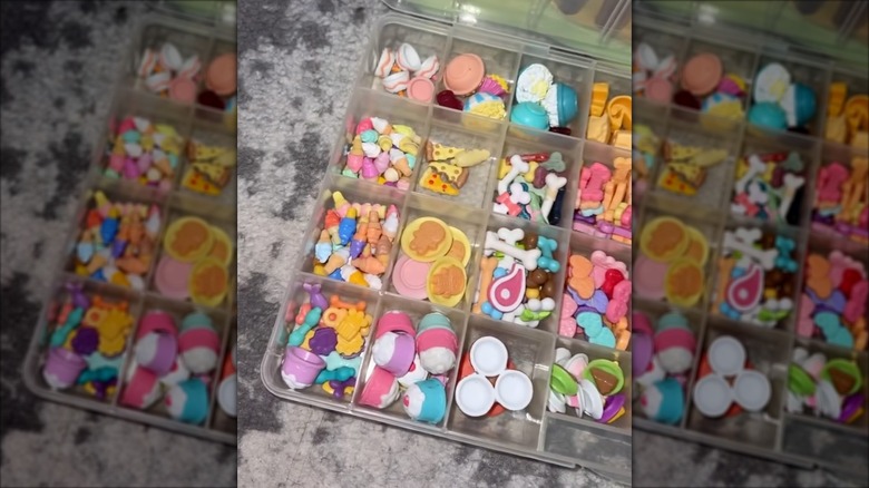 An open clear tackle box holding small toys.