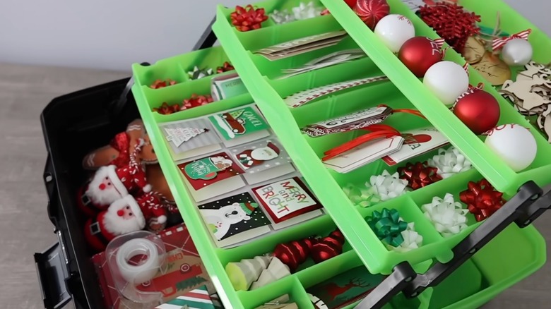 A green and black tackle box filled with holiday decor.