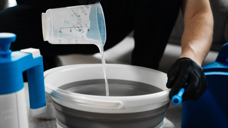 Pouring bleach into a bucket
