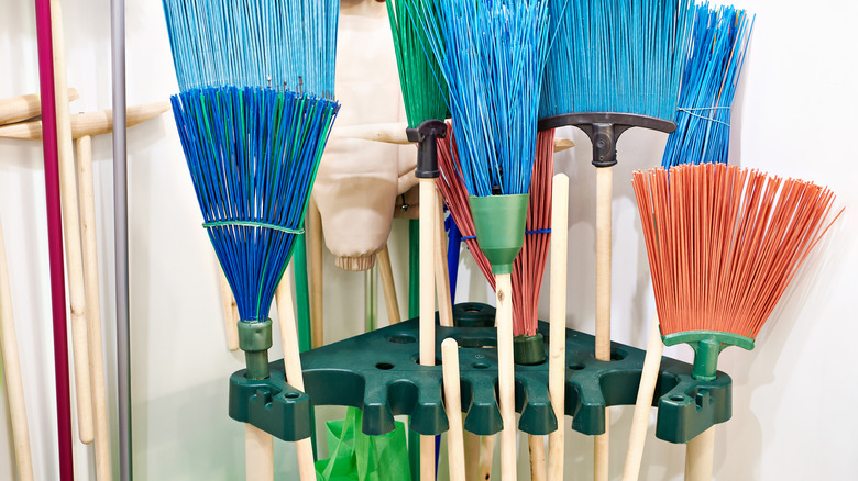 Brooms being stored hanging up