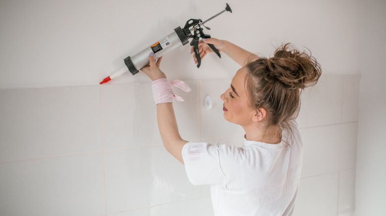 person holding a caulk gun