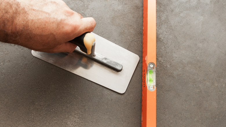 Smoothing wet concrete.