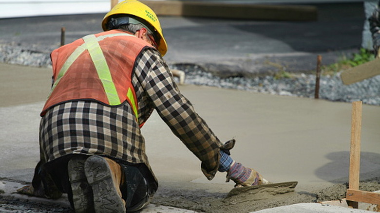 Wearing PPE while pouring concrete.