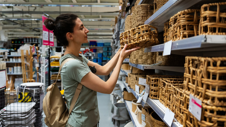Woman picks out baskets to use as a storage solution on her shelves.