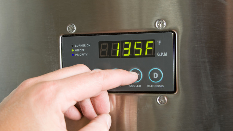 Person adjusting tankless water heater settings