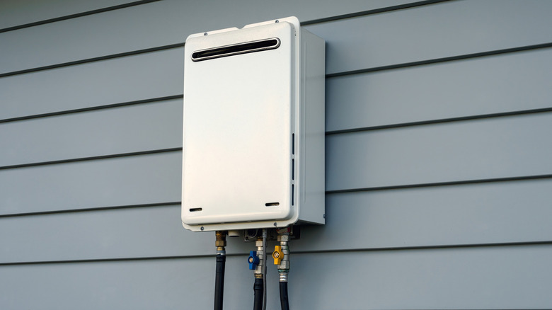 A tankless water heater installed on the side of a home