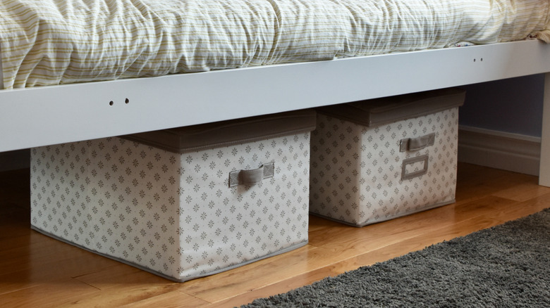 Patterned white and gray bins under bed with lids