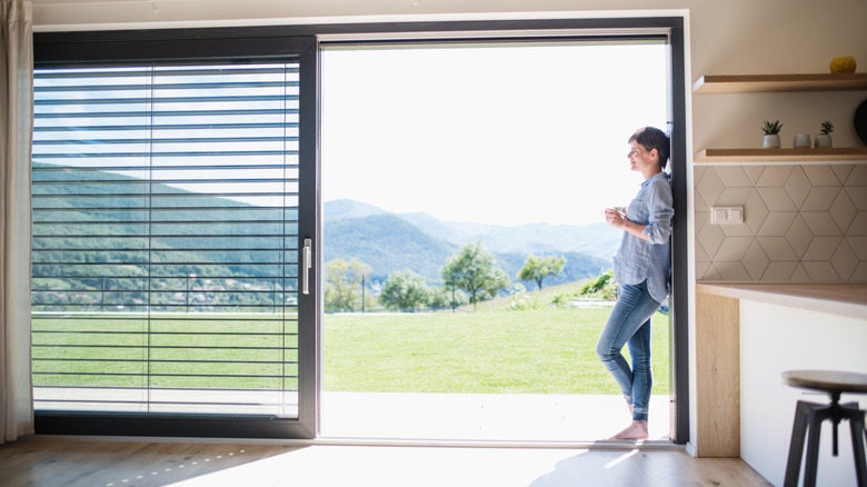 Woman standing in sliding glass doorway