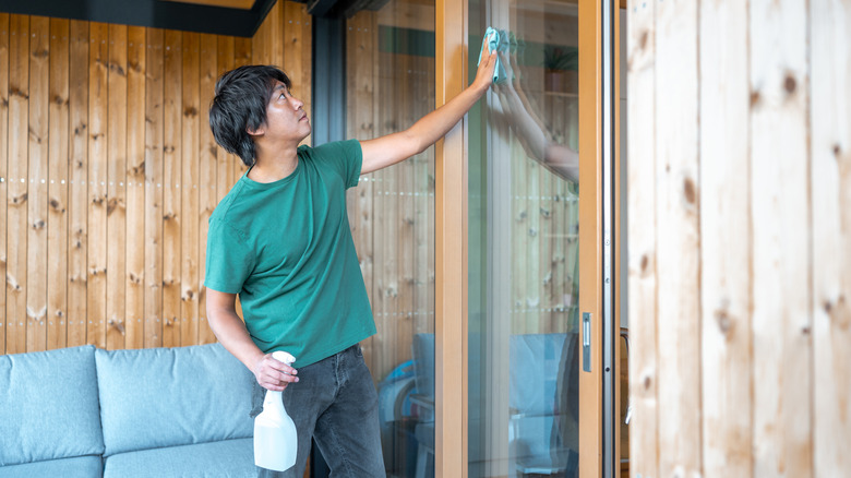 Man cleaning sliding glass door window