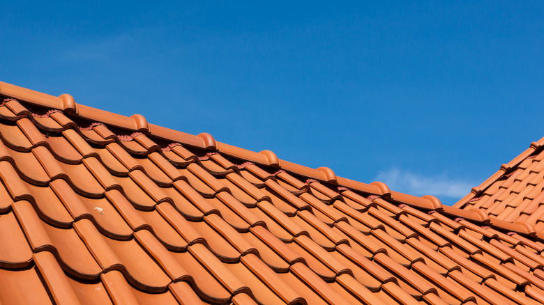 Orange clay roofing tiles with clear blue sky background