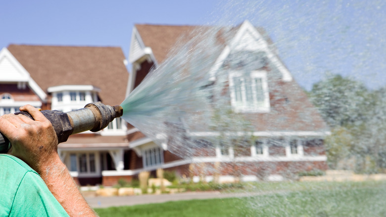 person hydroseeding lawn